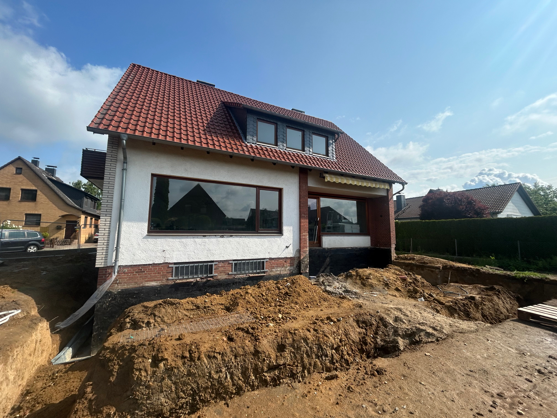 Hausansicht mit Erdarbeiten rund um das Gebäude